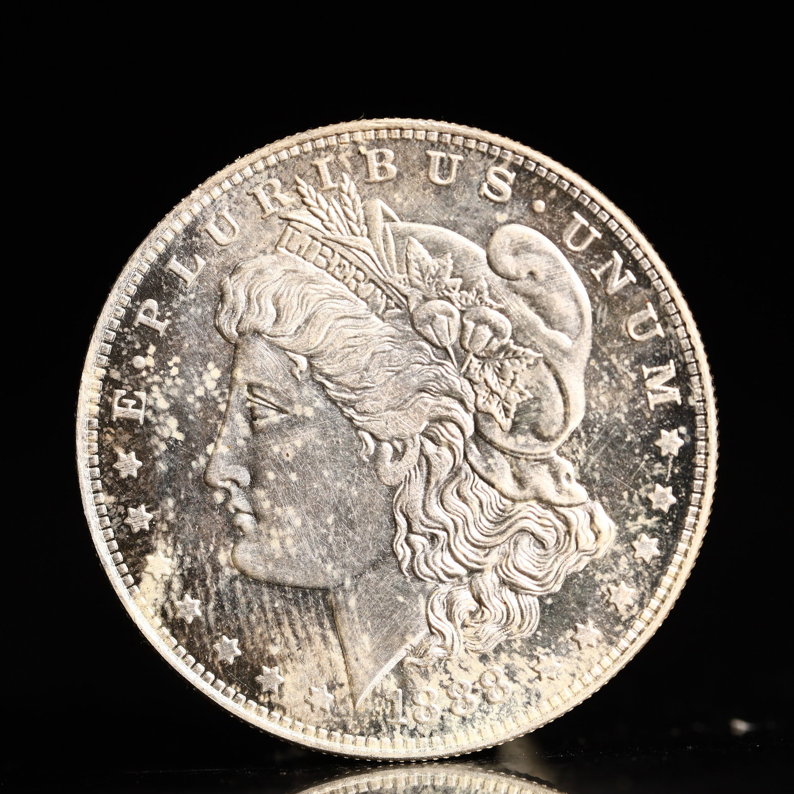 USA Morgan Dollar 1888 Coin: Obv: profile bust with date below and E PLURIBUS UNUM legend and stars around. Rev: eagle with In God we trust above within wreath with UNITED STATES OF AMERICA ONE DOLLAR legend. IN GOD WE TRUST / LI
