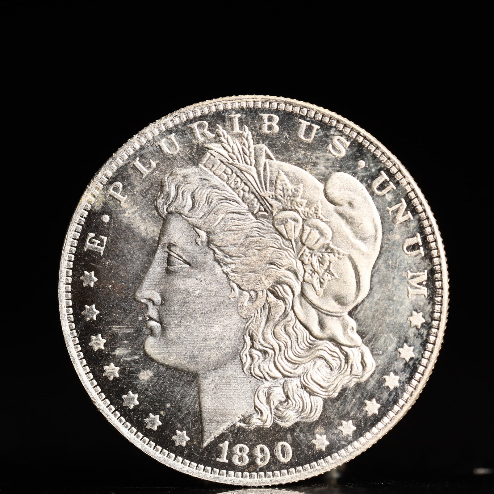 USA Morgan Dollar 1890 Coin: Obv: profile bust with date below and E PLURIBUS UNUM legend and stars around. Rev: eagle with In God we trust above within wreath with UNITED STATES OF AMERICA ONE DOLLAR legend. IN GOD WE TRUST / LI