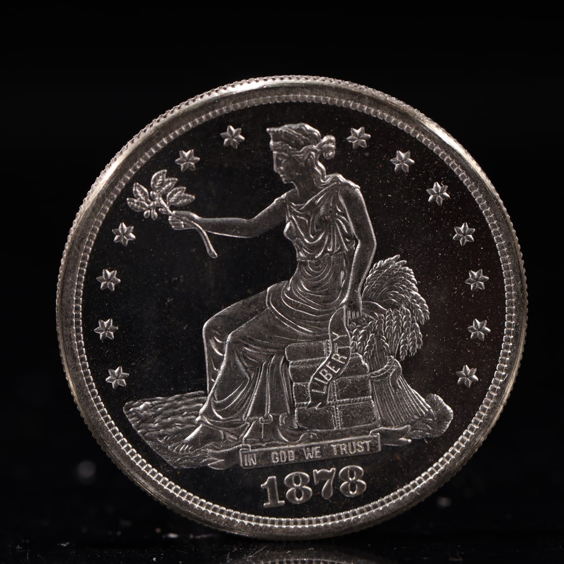USA Trade Dollar 1878 Coin: American coin. Obverse: Liberty seated on a pedestal facing the sea to the left holding olive branches surrounded by 13 stars. IN GOD WE TRUST / LIBERTY / 1878. Reverse: An eagle holding branches with