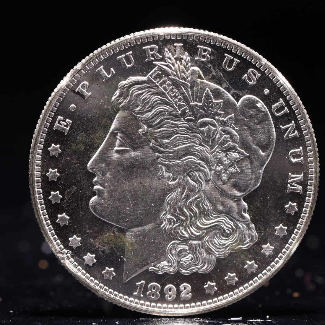 USA Morgan Dollar 1892 Coin: Obv: profile bust with date below and E PLURIBUS UNUM legend and stars around. Rev: eagle with In God we trust above within wreath with UNITED STATES OF AMERICA ONE DOLLAR legend. IN GOD WE TRUST / LI