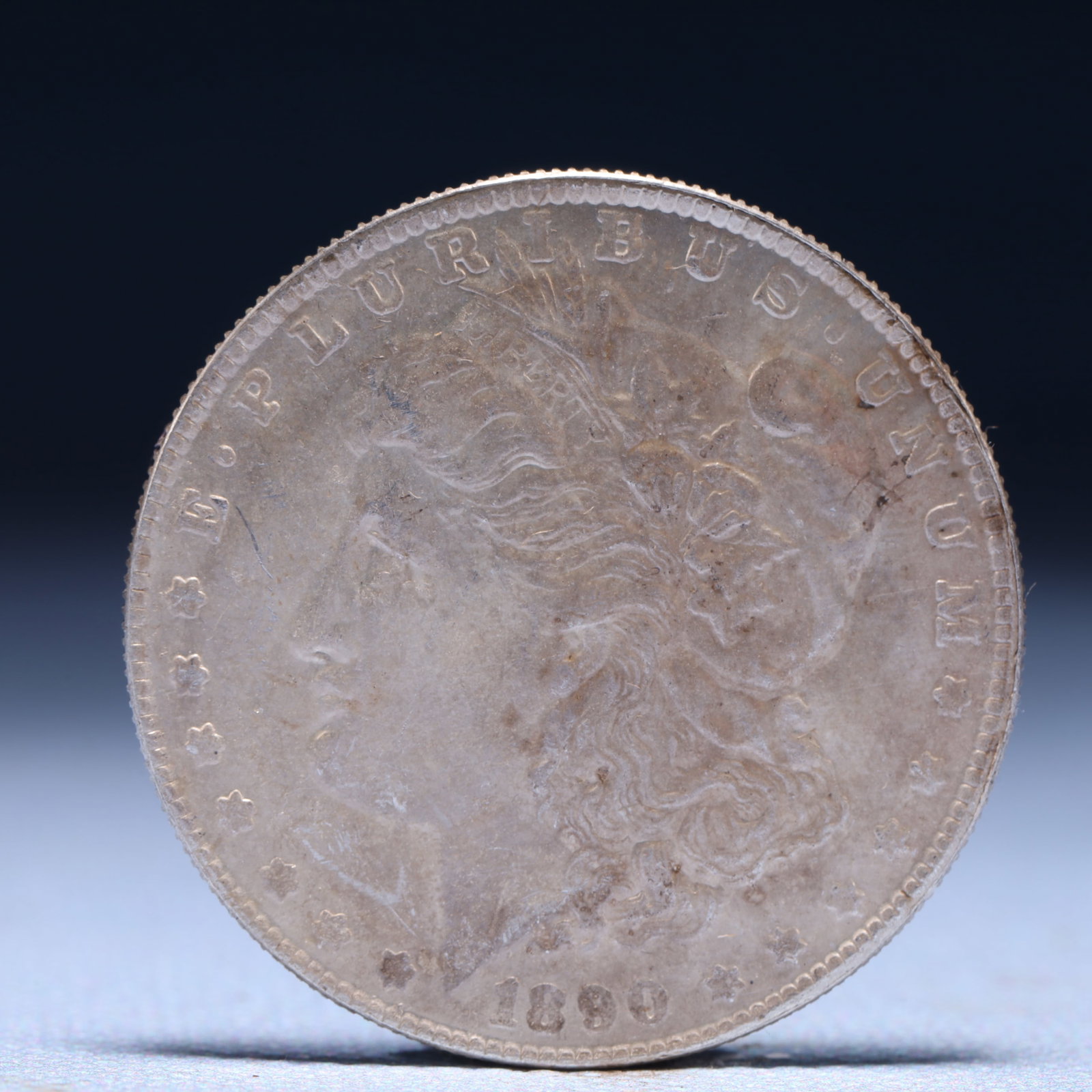 USA Morgan Dollar 1890 Coin: Obv: profile bust with date below and E PLURIBUS UNUM legend and stars around. Rev: eagle with In God we trust above within wreath with UNITED STATES OF AMERICA ONE DOLLAR legend. IN GOD WE TRUST / LI