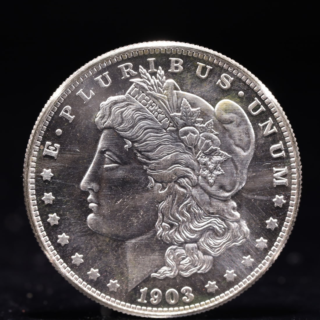 USA Morgan Dollar 1903 Coin: Obv: profile bust with date below and E PLURIBUS UNUM legend and stars around. Rev: eagle with In God we trust above within wreath with UNITED STATES OF AMERICA ONE DOLLAR legend. IN GOD WE TRUST / LI