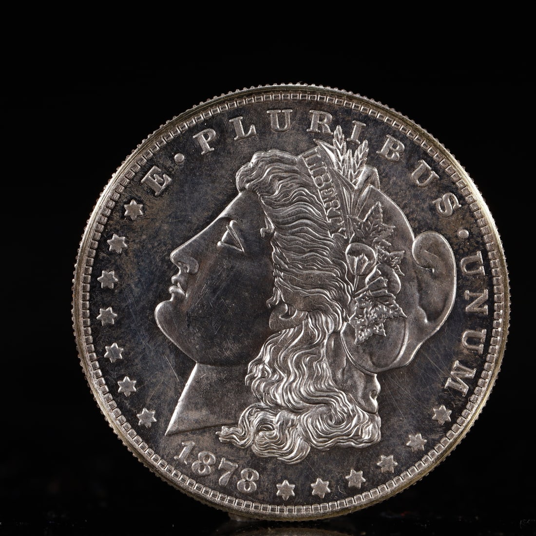 USA Morgan Dollar 1878 Coin: Obv: profile bust with date below and E PLURIBUS UNUM legend and stars around. Rev: eagle with In God we trust above within wreath with UNITED STATES OF AMERICA ONE DOLLAR legend. IN GOD WE TRUST / LI