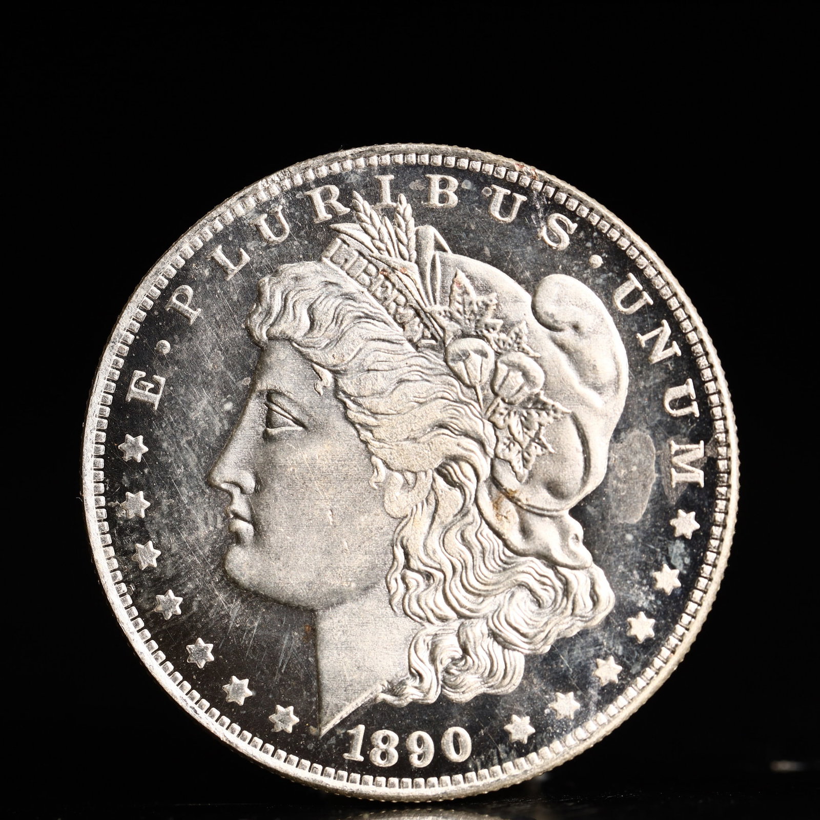 USA Morgan Dollar 1890 Coin: Obv: profile bust with date below and E PLURIBUS UNUM legend and stars around. Rev: eagle with In God we trust above within wreath with UNITED STATES OF AMERICA ONE DOLLAR legend. IN GOD WE TRUST / LI