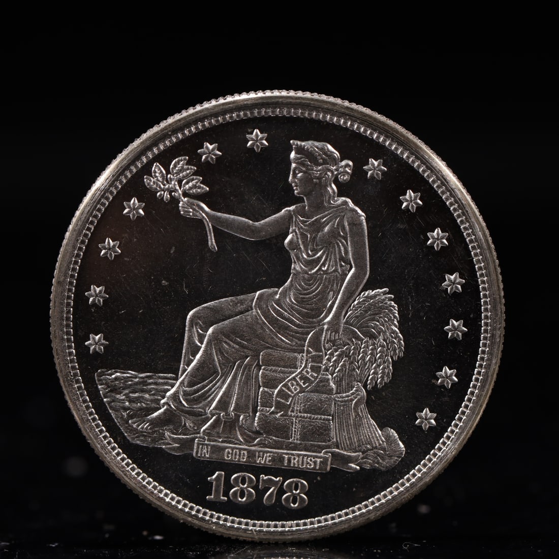 USA Trade Dollar 1878 Coin: American coin. Obverse: Liberty seated on a pedestal facing the sea to the left holding olive branches surrounded by 13 stars. IN GOD WE TRUST / LIBERTY / 1878. Reverse: An eagle holding branches with