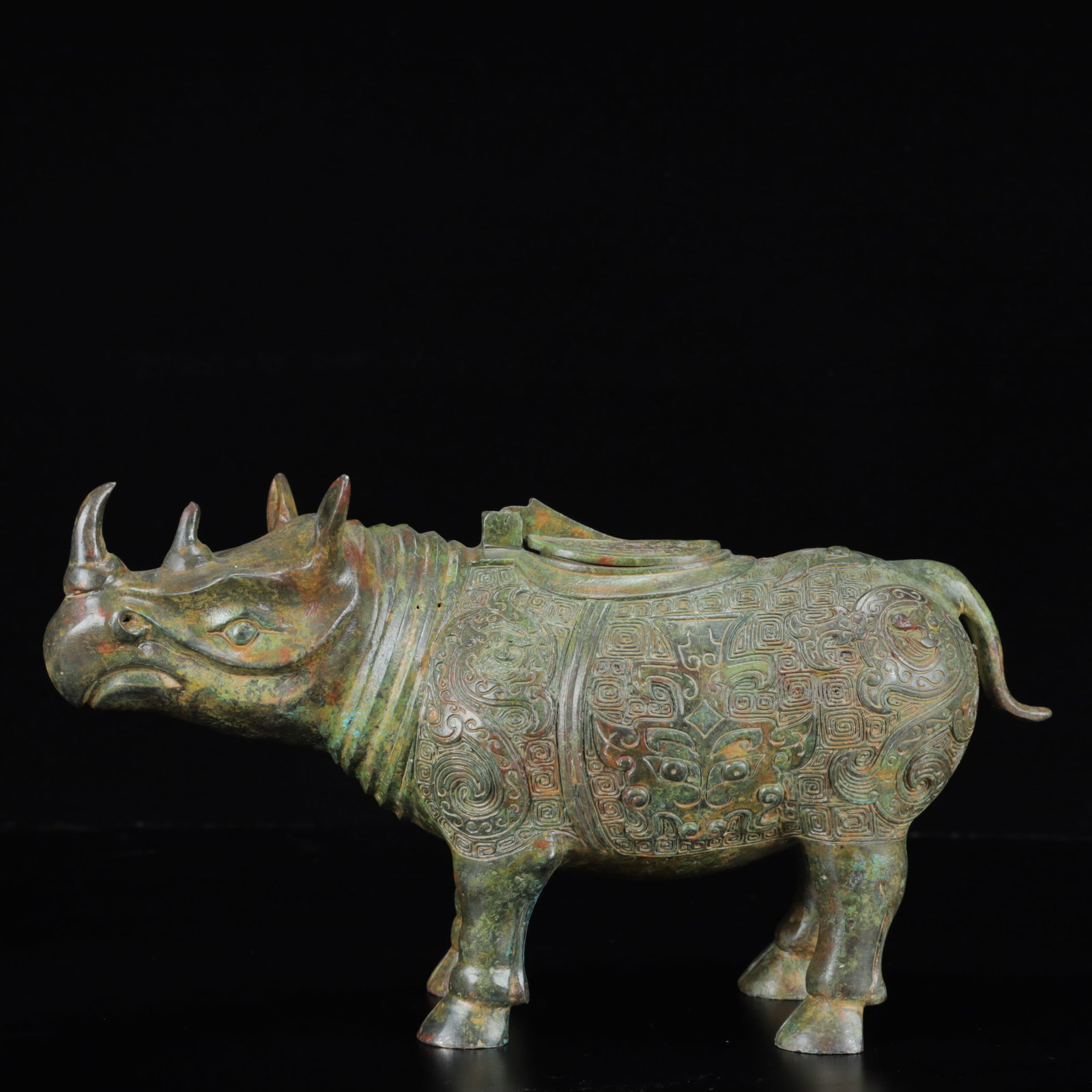 An Archaic Bronze Beast-Face Pattern Rhinoceros Ornament: An Archaic Bronze Beast-Face Pattern Rhinoceros Ornament,the Warring States Period in China,Size:11.4inx3.5inx6.7in,Weight:1850g 青铜兽面纹犀牛摆件