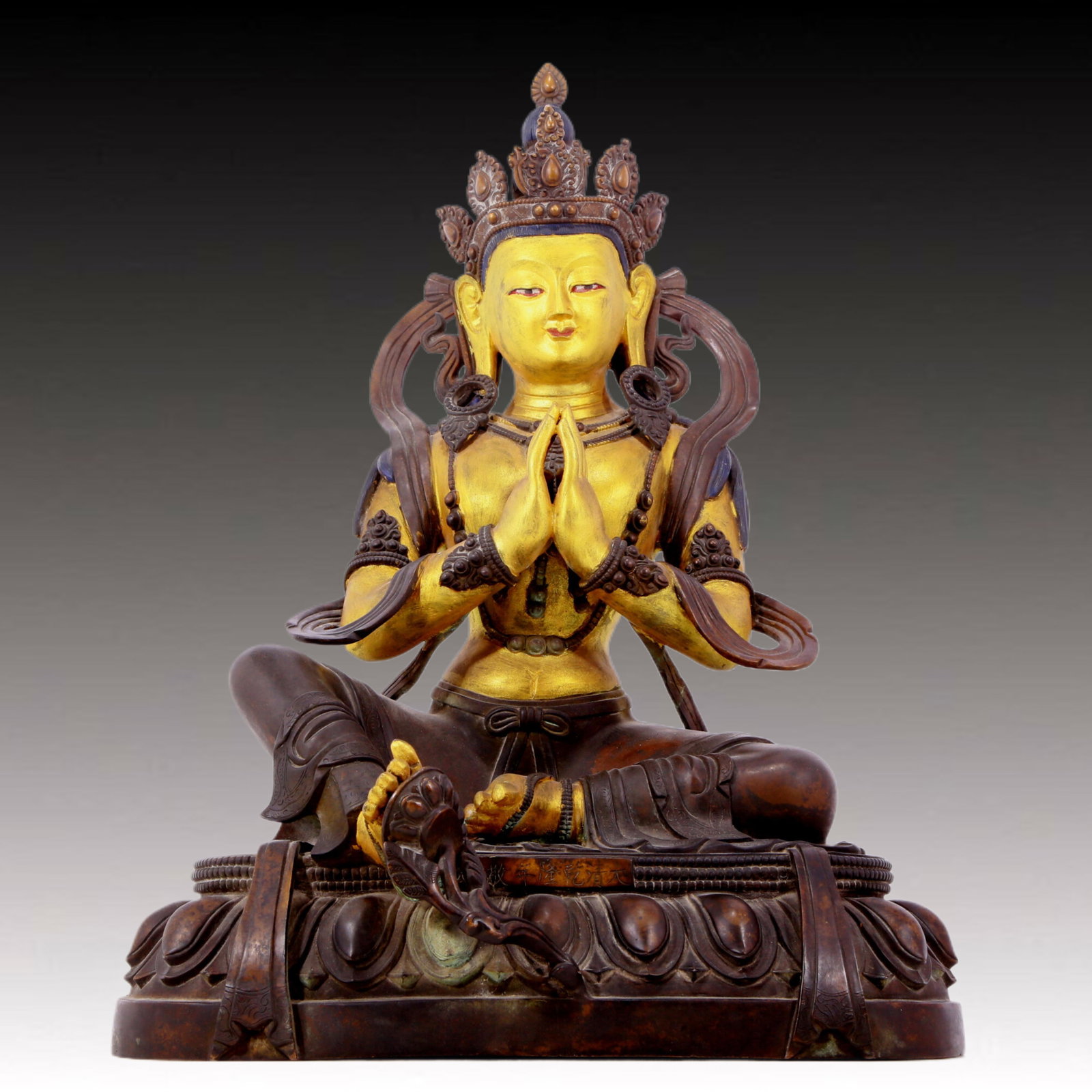 A solemn gilt bronze statue of green Tara: solemn gilt-bronze green Tara statue, Qianlong seven-character inscription, Qing Dynasty, China. Tara has an elegant posture with a peaceful and compassionate expression. Her face is soft and solemn, 