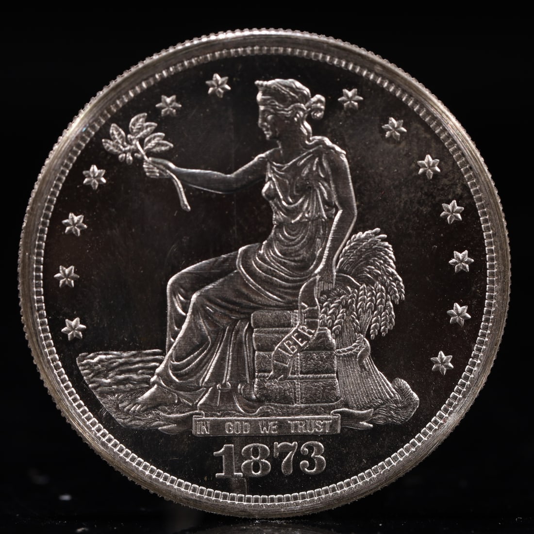 USA Trade Dollar 1873 Coin: American coin. Obverse: Liberty seated on a pedestal facing the sea to the left holding olive branches surrounded by 13 stars. IN GOD WE TRUST / LIBERTY / 1873. Reverse: An eagle holding branches with