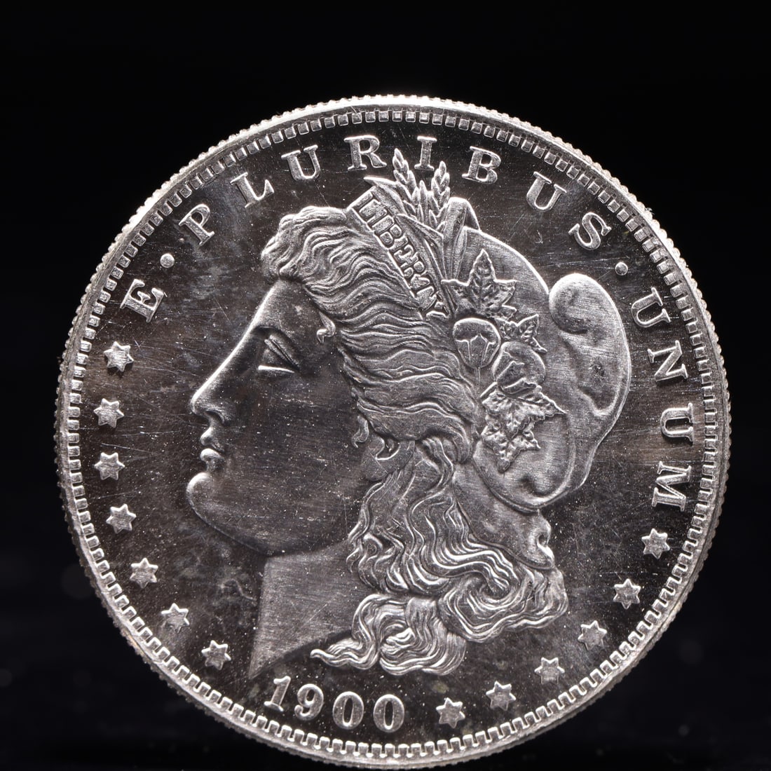 USA Morgan Dollar 1900 Coin: Obv: profile bust with date below and E PLURIBUS UNUM legend and stars around. Rev: eagle with In God we trust above within wreath with UNITED STATES OF AMERICA ONE DOLLAR legend. IN GOD WE TRUST / LI
