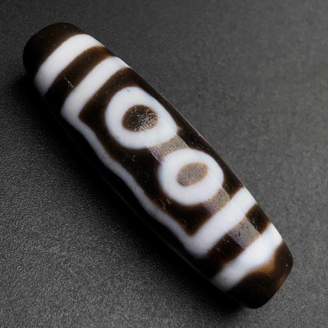 An Exquisite Five Eyes Dzi Bead Pendant: Estimated Value:300-600 An Exquisite Five Eyes Dzi Bead Pendant,Size:39mmx11mm,Weight:7.7g 五眼天珠挂件