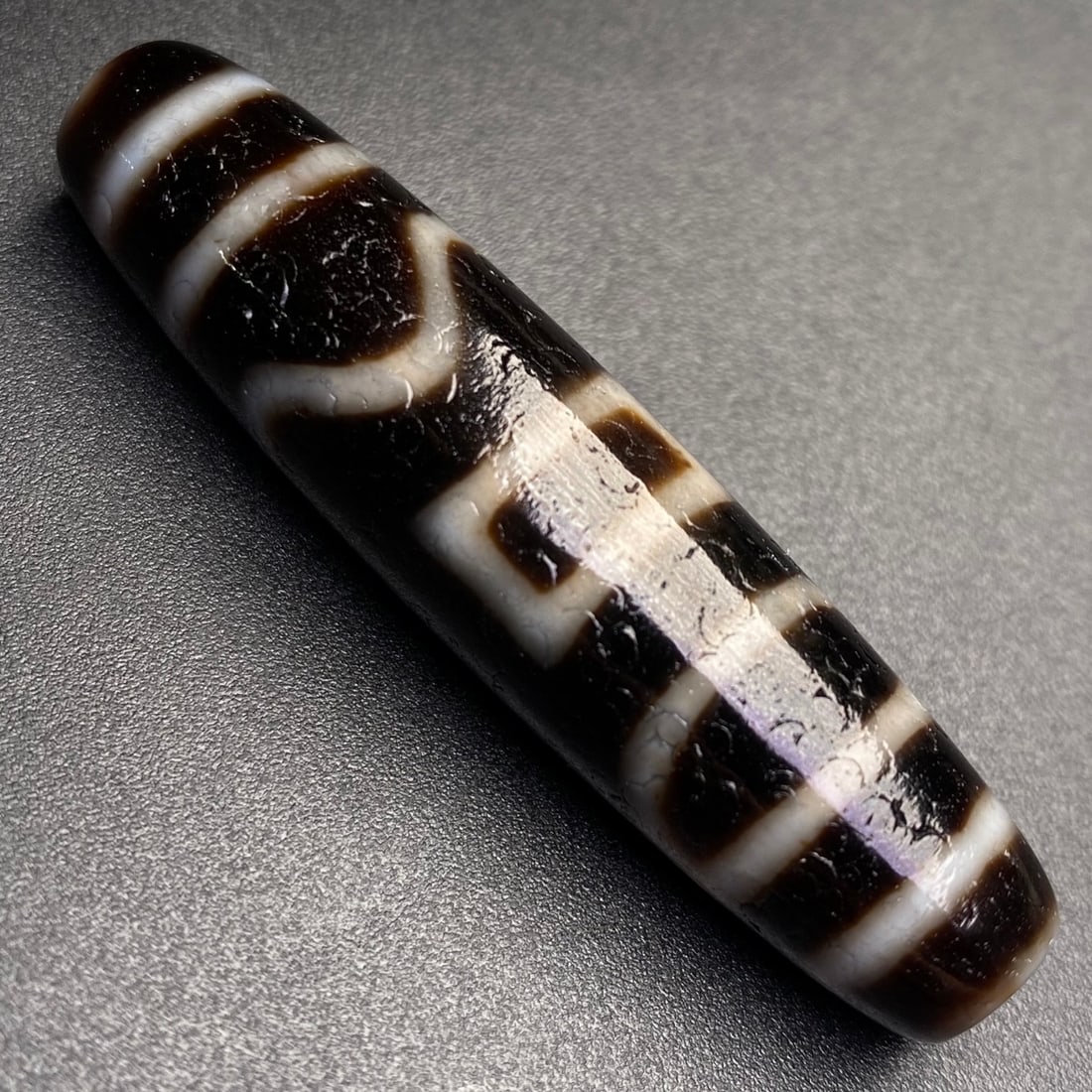 An Exquisite Dzi Bead Pendant: Estimated Value:600-1200 An Exquisite Dzi Bead Pendant,Size:54mmx13mm,Weight:14.4g 天珠挂件