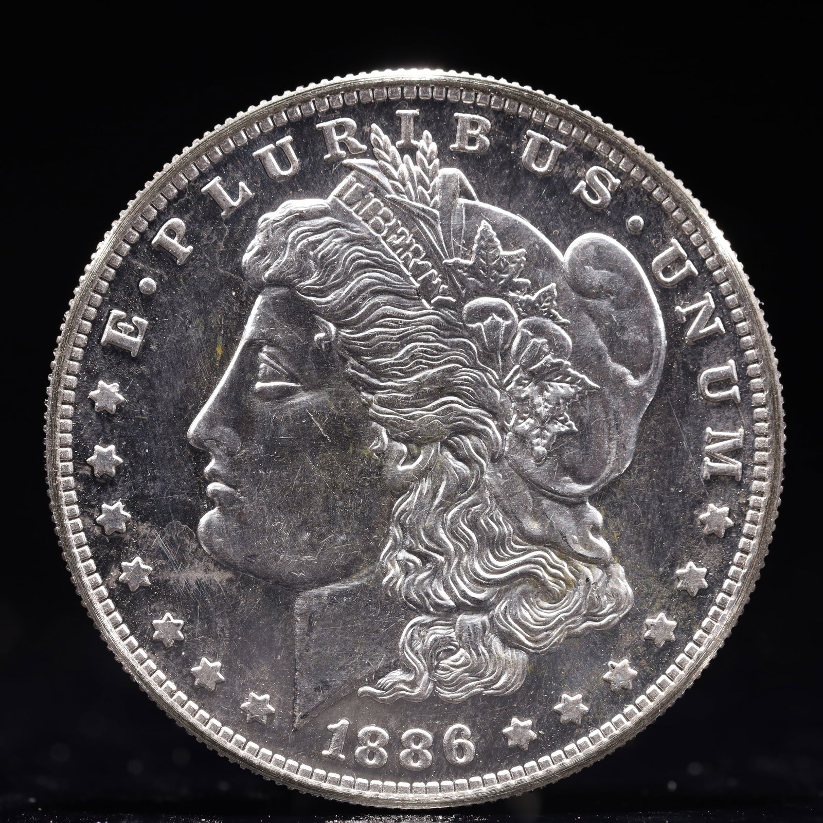 USA Morgan Dollar 1886 Coin: Estimated Value:2000-4000 Obv: profile bust with date below and E PLURIBUS UNUM legend and stars around. Rev: eagle with In God we trust above within wreath with UNITED STATES OF AMERICA ONE DOLLAR