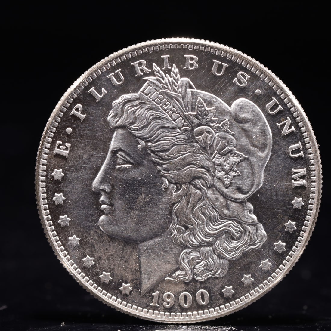 USA Morgan Dollar 1900 Coin: Obv: profile bust with date below and E PLURIBUS UNUM legend and stars around. Rev: eagle with In God we trust above within wreath with UNITED STATES OF AMERICA ONE DOLLAR legend. IN GOD WE TRUST /