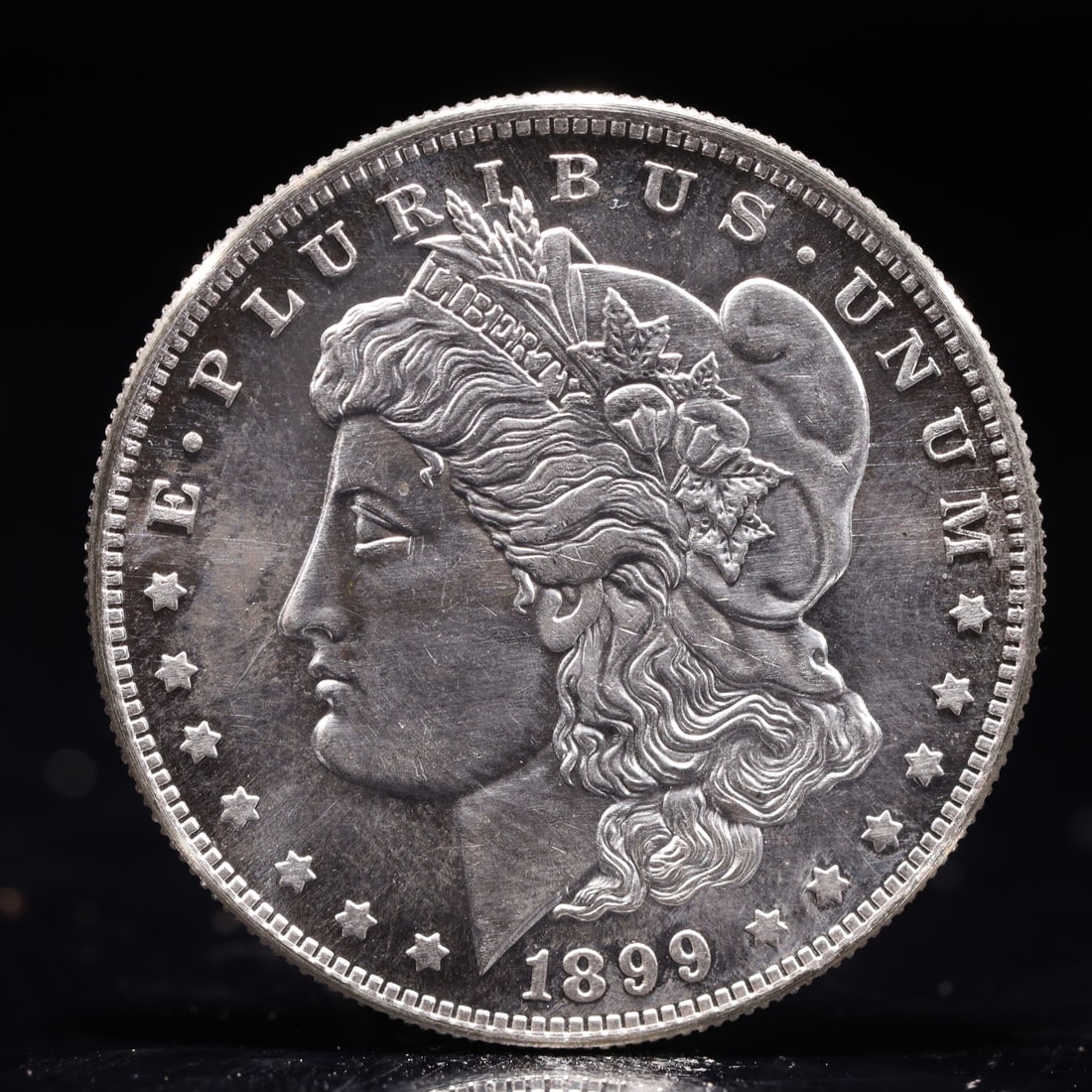 USA Morgan Dollar 1899 Coin: Obv: profile bust with date below and E PLURIBUS UNUM legend and stars around. Rev: eagle with In God we trust above within wreath with UNITED STATES OF AMERICA ONE DOLLAR legend. IN GOD WE TRUST / LI