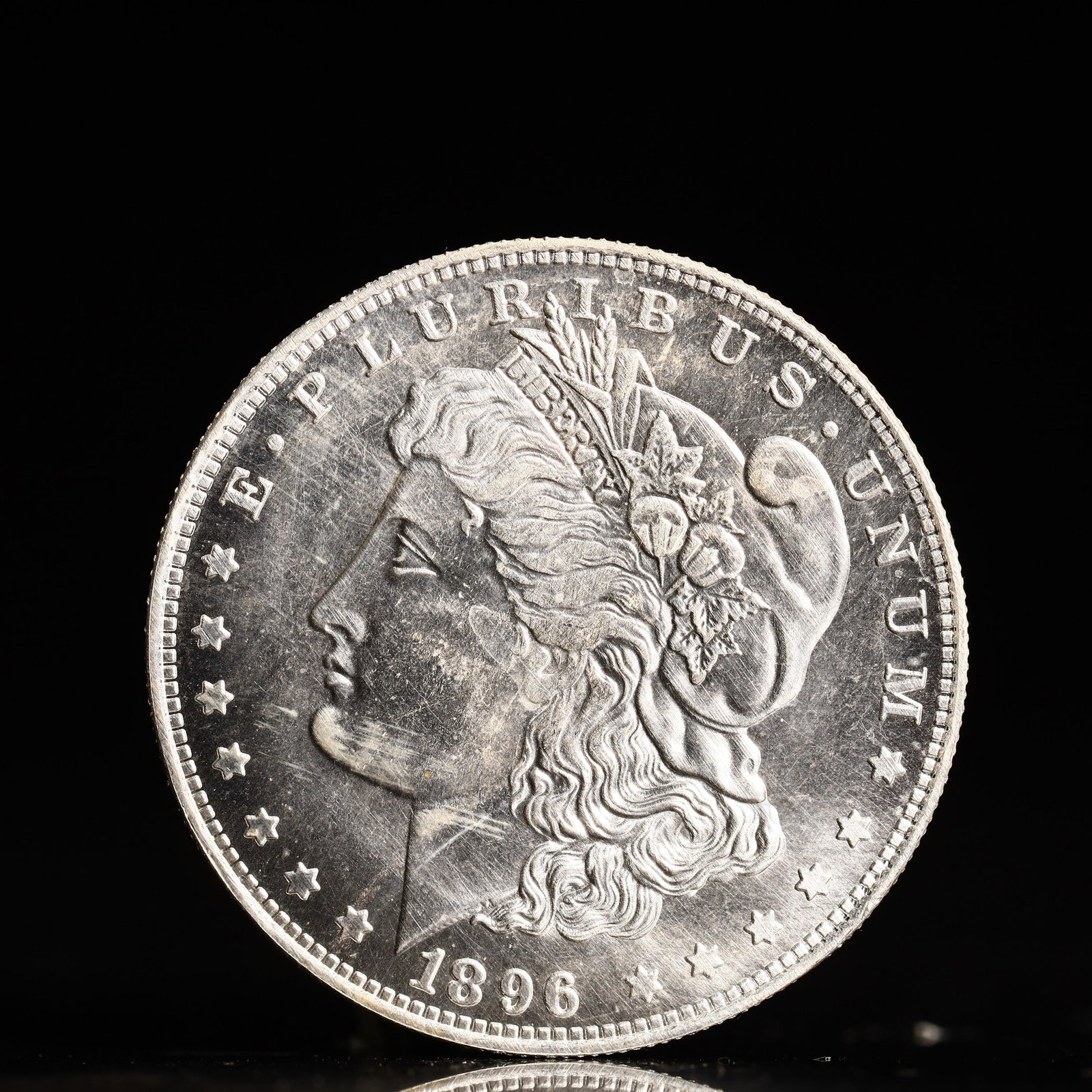 USA Morgan Dollar 1896 Coin: Obv: profile bust with date below and E PLURIBUS UNUM legend and stars around. Rev: eagle with In God we trust above within wreath with UNITED STATES OF AMERICA ONE DOLLAR legend. IN GOD WE TRUST / LI