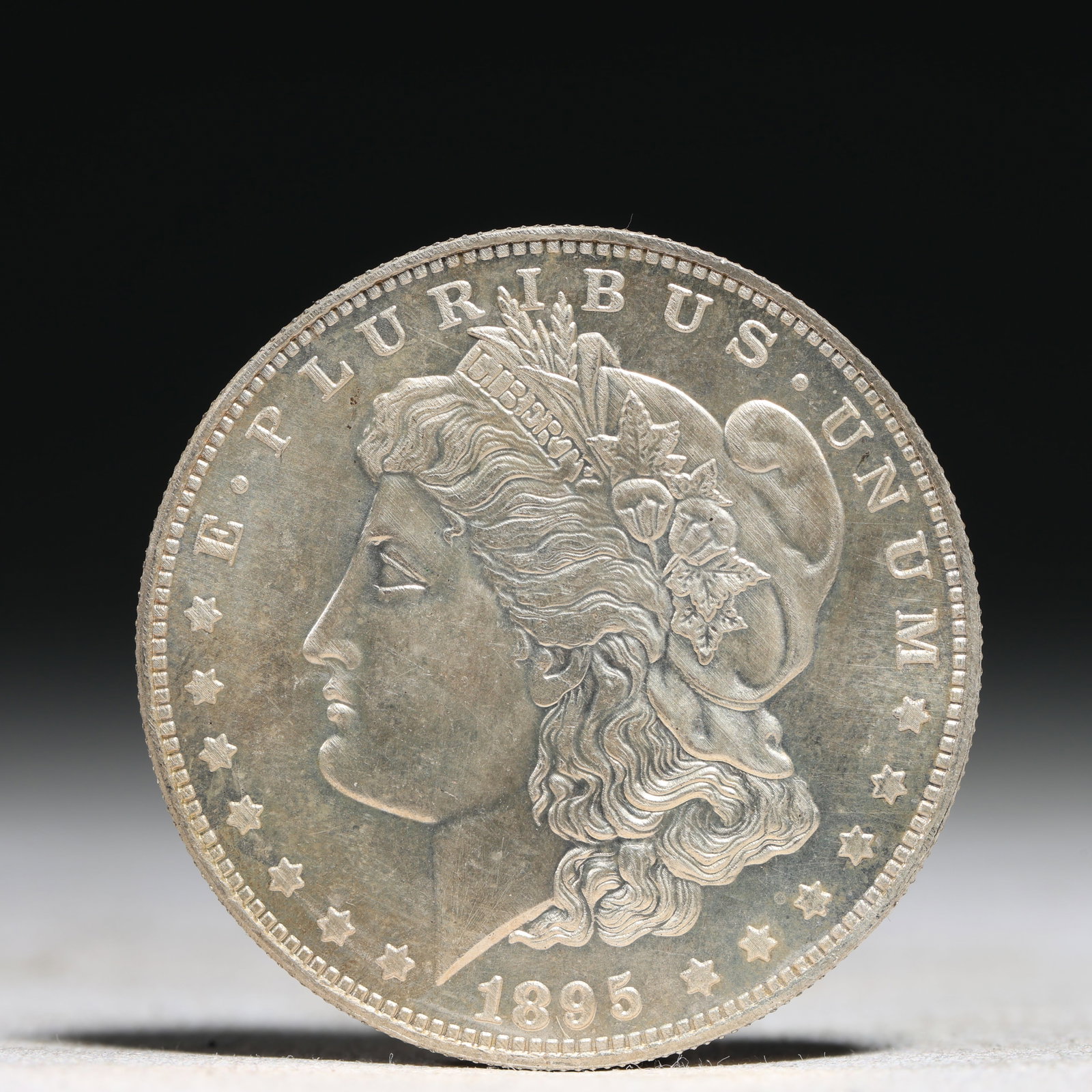 USA Morgan Dollar 1895 Coin: Obv: profile bust with date below and E PLURIBUS UNUM legend and stars around. Rev: eagle with In God we trust above within wreath with UNITED STATES OF AMERICA ONE DOLLAR legend. IN GOD WE TRUST / LI