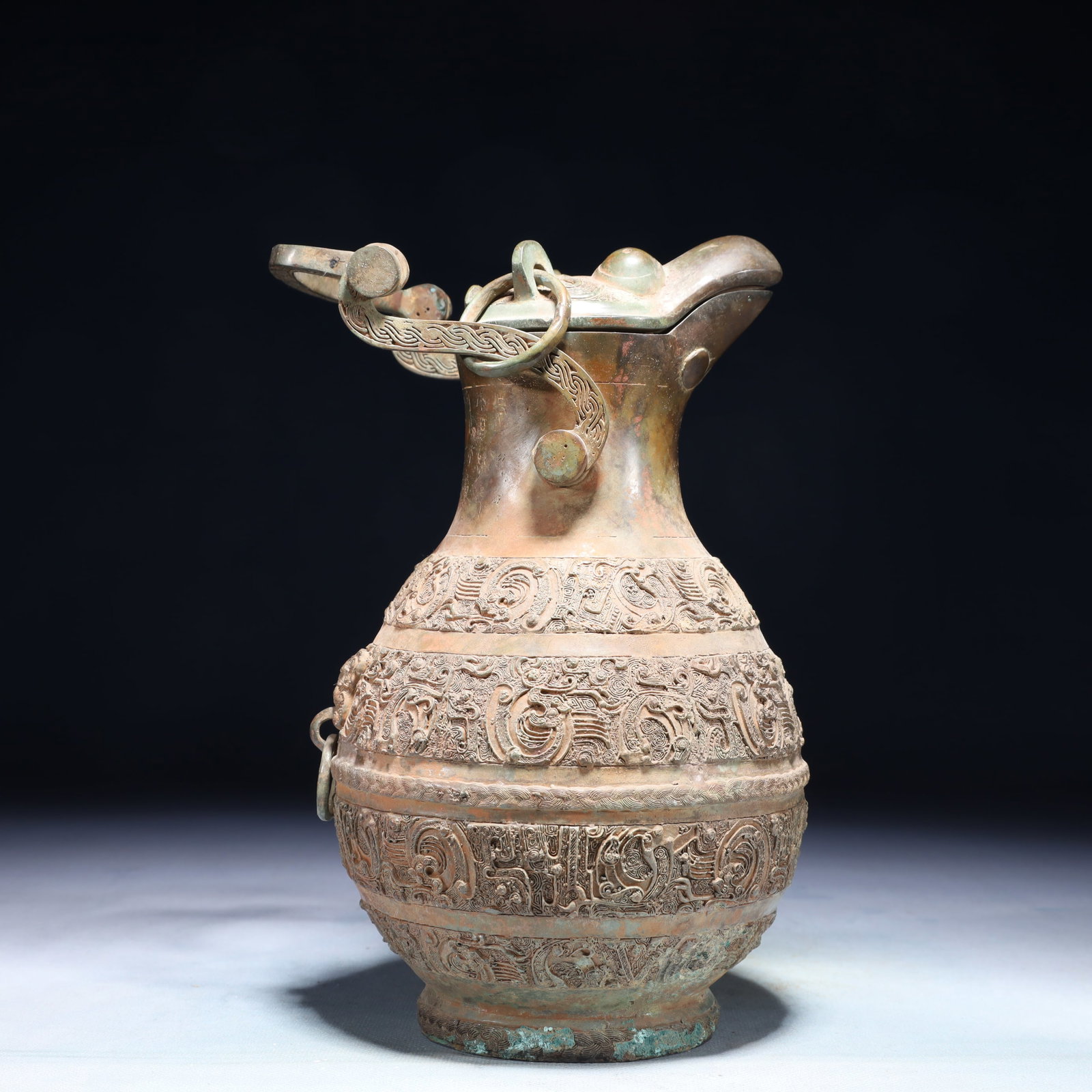 A Rare Bronze Chi-Dragon Pattern Loop-Handled Pot,With Inscription: A Rare Bronze Chi-Dragon Pattern Loop-Handled Pot,With Inscription,the Warring States period in China,Size:5.9inx11in,Weight:1700g 青铜螭龙纹提梁壶,