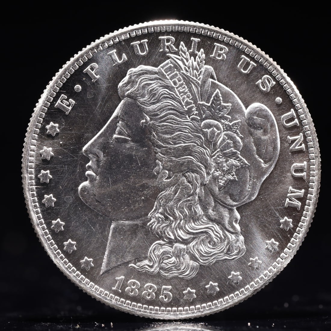 USA Morgan Dollar 1885 Coin: Obv: profile bust with date below and E PLURIBUS UNUM legend and stars around. Rev: eagle with In God we trust above within wreath with UNITED STATES OF AMERICA ONE DOLLAR legend. IN GOD WE TRUST / LI