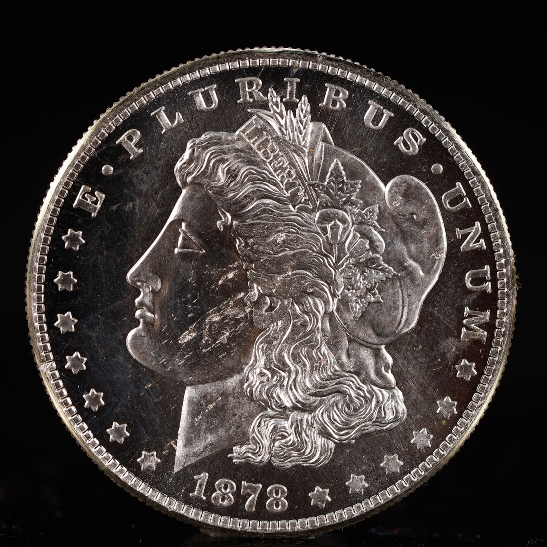 USA Morgan Dollar 1878 Coin: Obv: profile bust with date below and E PLURIBUS UNUM legend and stars around. Rev: eagle with In God we trust above within wreath with UNITED STATES OF AMERICA ONE DOLLAR legend. IN GOD WE TRUST / LI