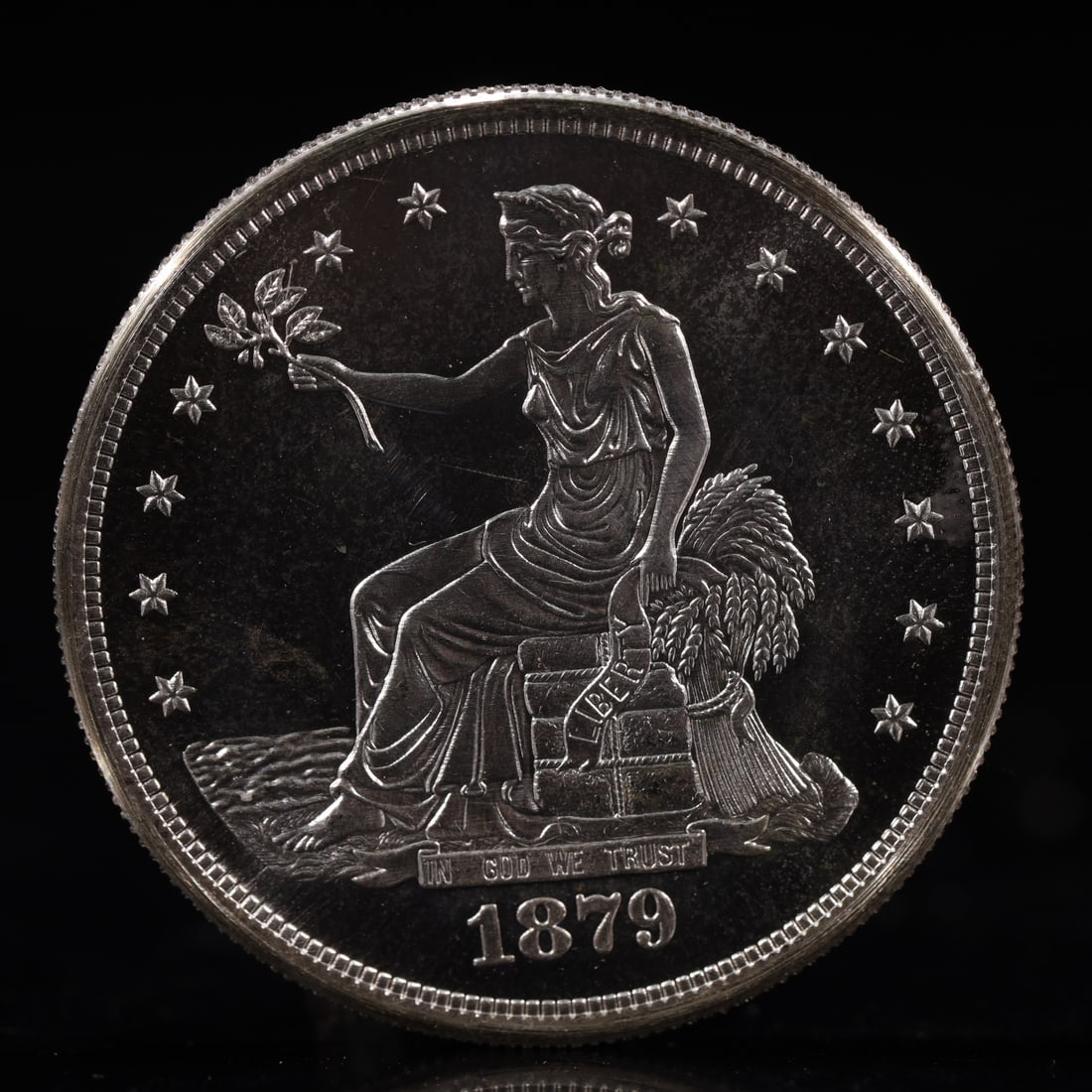 USA Trade Dollar 1879 Coin: American coin. Obverse: Liberty seated on a pedestal facing the sea to the left holding olive branches surrounded by 13 stars. IN GOD WE TRUST / LIBERTY / 1879. Reverse: An eagle holding branches with