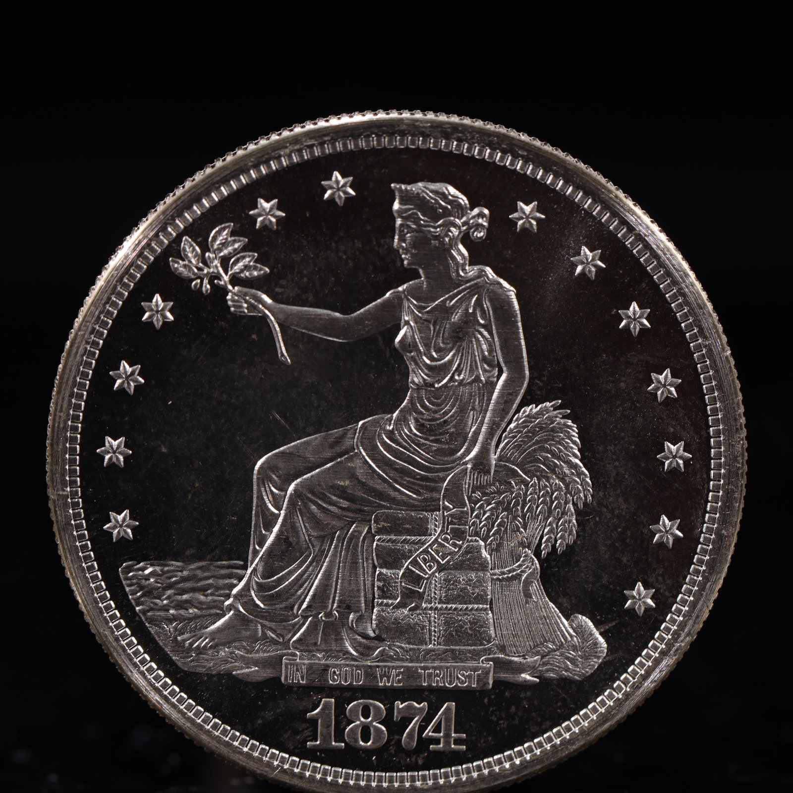 USA Trade Dollar 1874 Coin: American coin. Obverse: Liberty seated on a pedestal facing the sea to the left holding olive branches surrounded by 13 stars. IN GOD WE TRUST / LIBERTY / 1874. Reverse: An eagle holding branches with