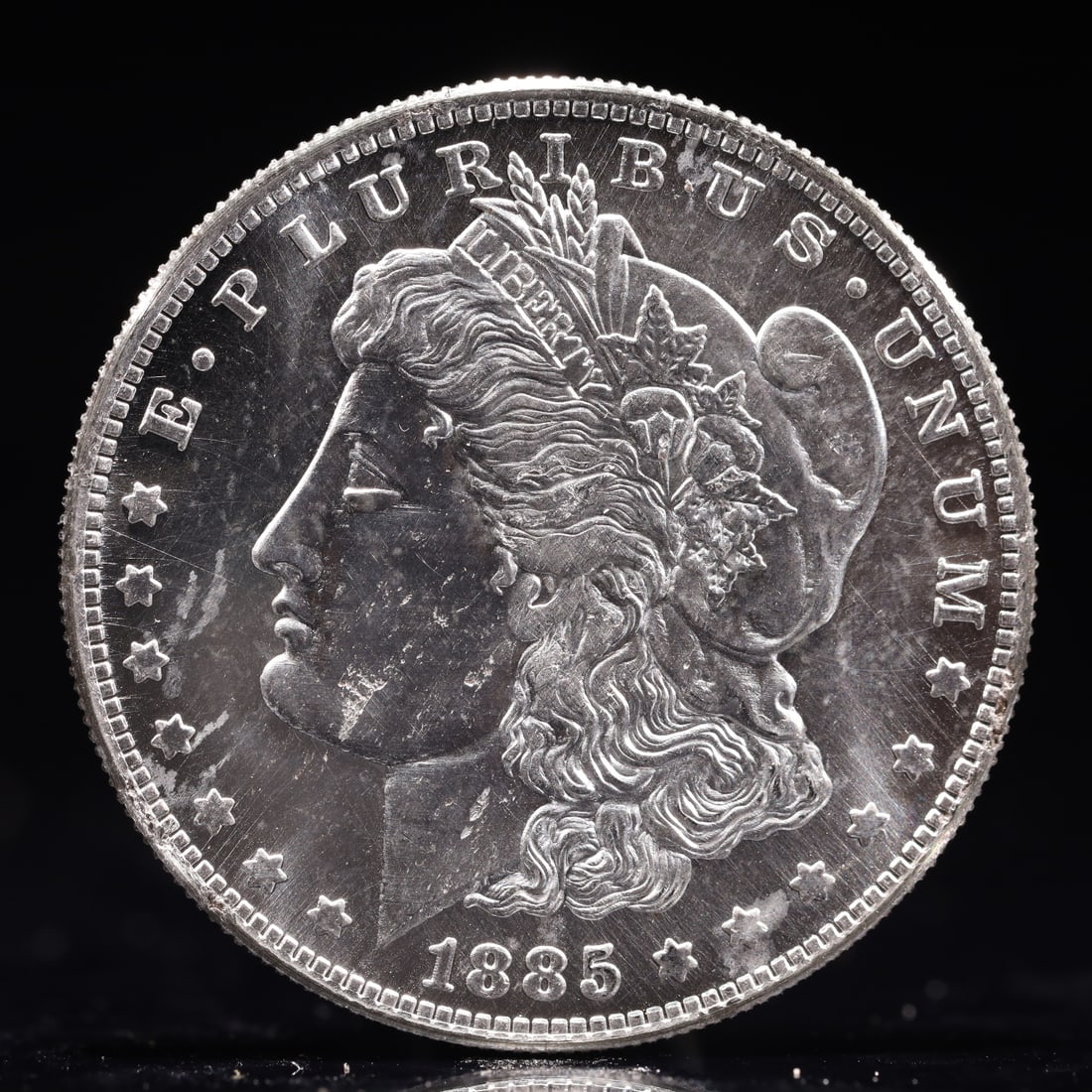 USA Morgan Dollar 1885 Coin: Obv: profile bust with date below and E PLURIBUS UNUM legend and stars around. Rev: eagle with In God we trust above within wreath with UNITED STATES OF AMERICA ONE DOLLAR legend. IN GOD WE TRUST / LI