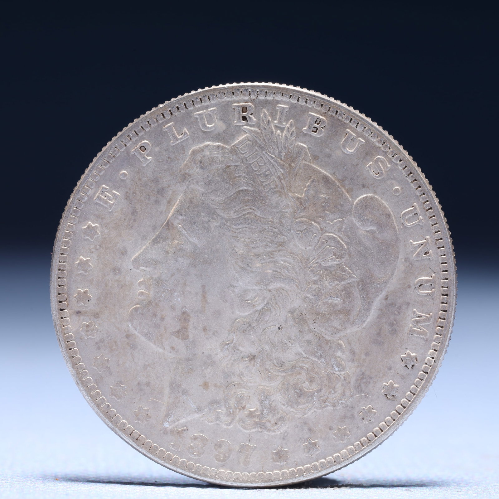 USA Morgan Dollar 1897 Coin: Obv: profile bust with date below and E PLURIBUS UNUM legend and stars around. Rev: eagle with In God we trust above within wreath with UNITED STATES OF AMERICA ONE DOLLAR legend. IN GOD WE TRUST /