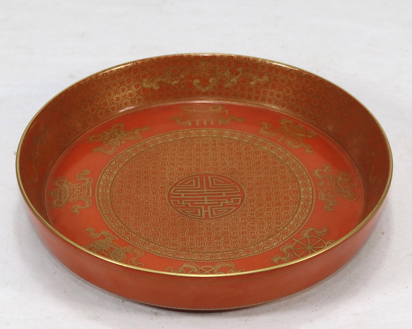 A fine cinnabar red ground gilt teapot stand with hidden eight auspicious symbols: A fine cinnabar red ground gilt teapot stand with hidden eight auspicious symbols, Qing Dynasty, China, with six-character Qianlong reign mark, Size:1.3inx6.6in 砂红地金彩