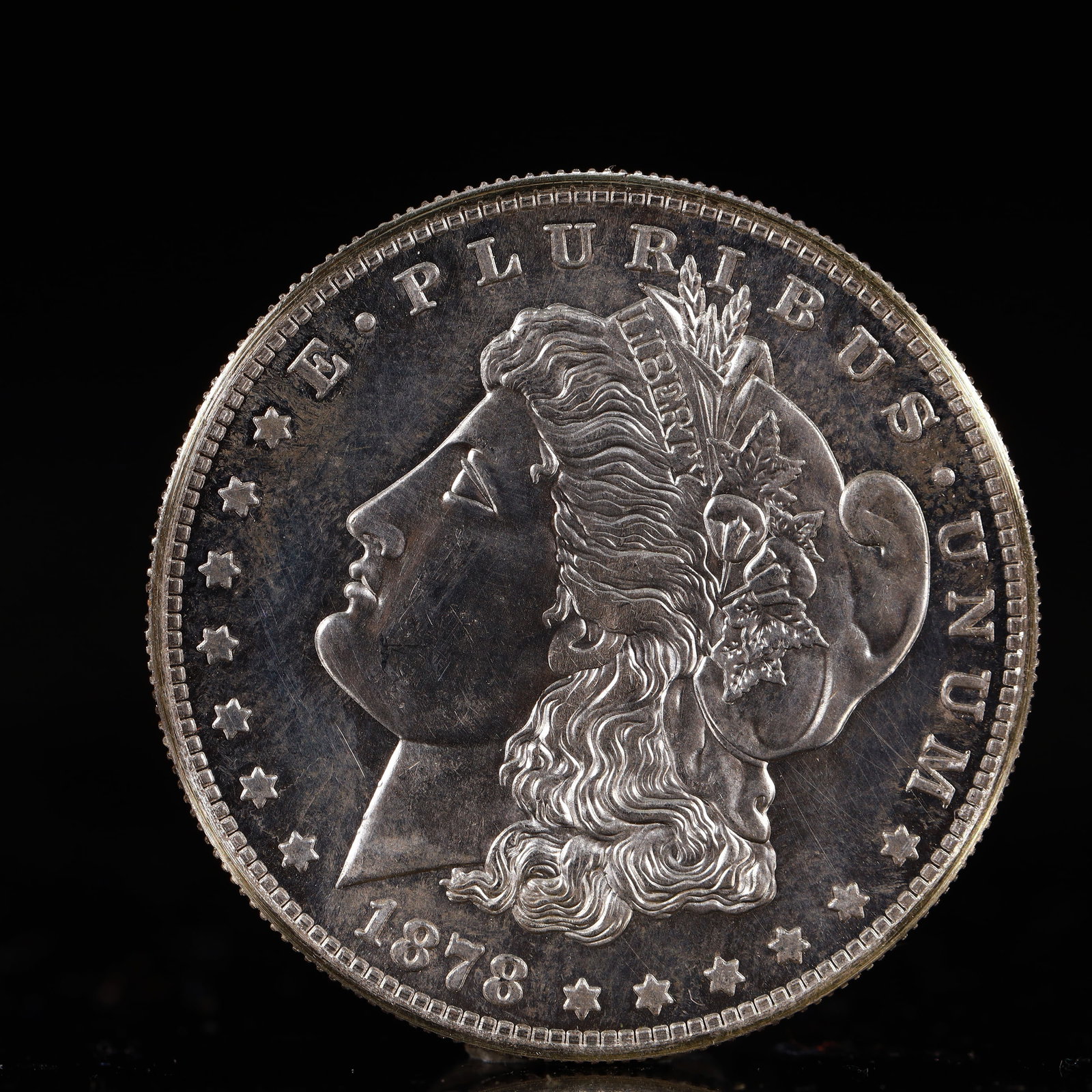 USA Morgan Dollar 1878 Coin: Obv: profile bust with date below and E PLURIBUS UNUM legend and stars around. Rev: eagle with In God we trust above within wreath with UNITED STATES OF AMERICA ONE DOLLAR legend. IN GOD WE TRUST /