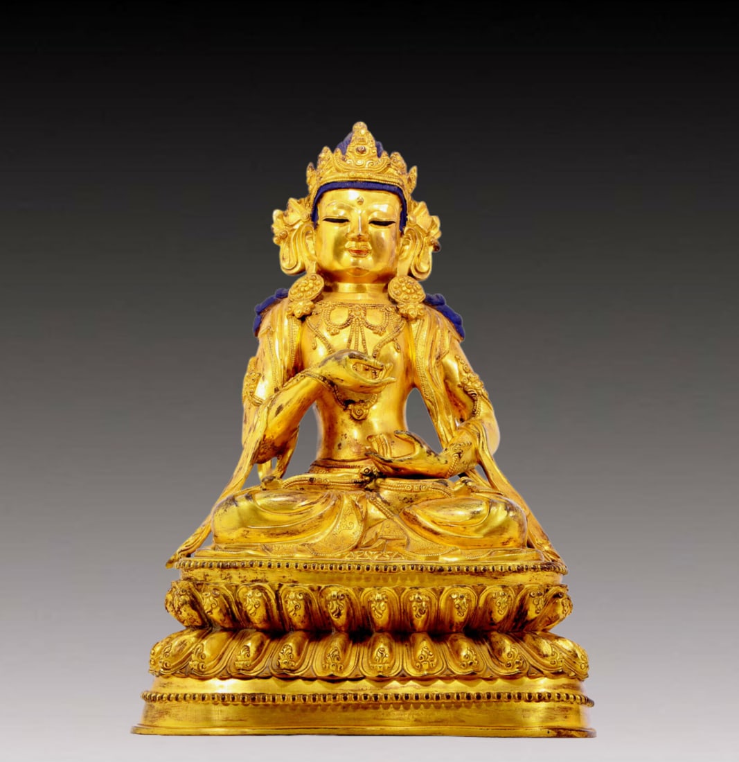 A solemn gilt bronze statue of Bodhisattva: A solemn gilt-bronze Bodhisattva statue from the Ming Dynasty in China. The Bodhisattva's posture is graceful and peaceful. His face is solemn and kind, and his eyes are deep, as if he can see into th