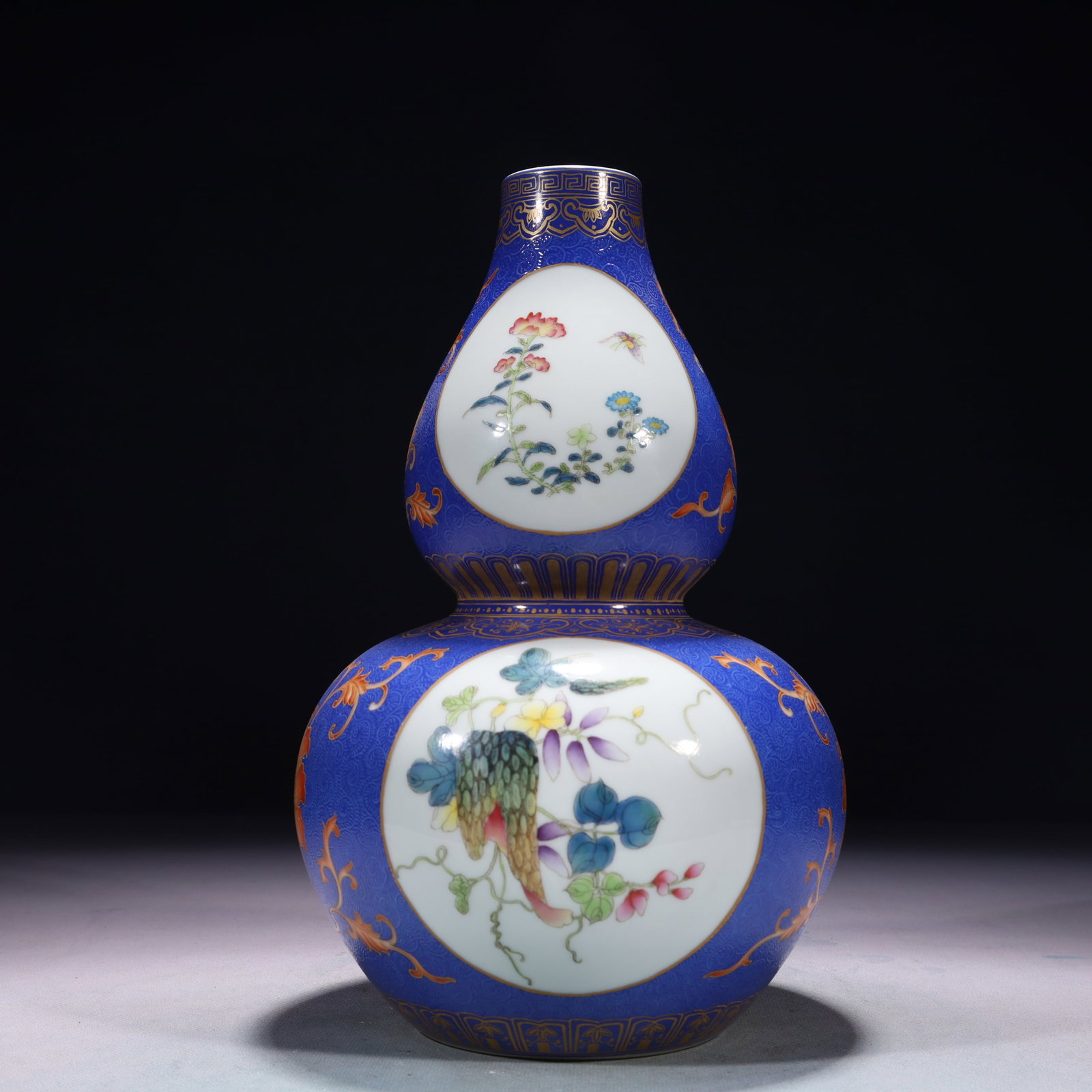 An Exquisite Blue Ground Famille-Rose Flower and Butterfly Pattern Gourd-Shaped Vase: An Exquisite Blue Ground Famille-Rose Flower and Butterfly Pattern Gourd-Shaped Vase,Qing Dynasty,China,Qianlong Six-character Mark,Size:6.3inx10.6in,Weight:1600g 蓝地粉彩Ŏ