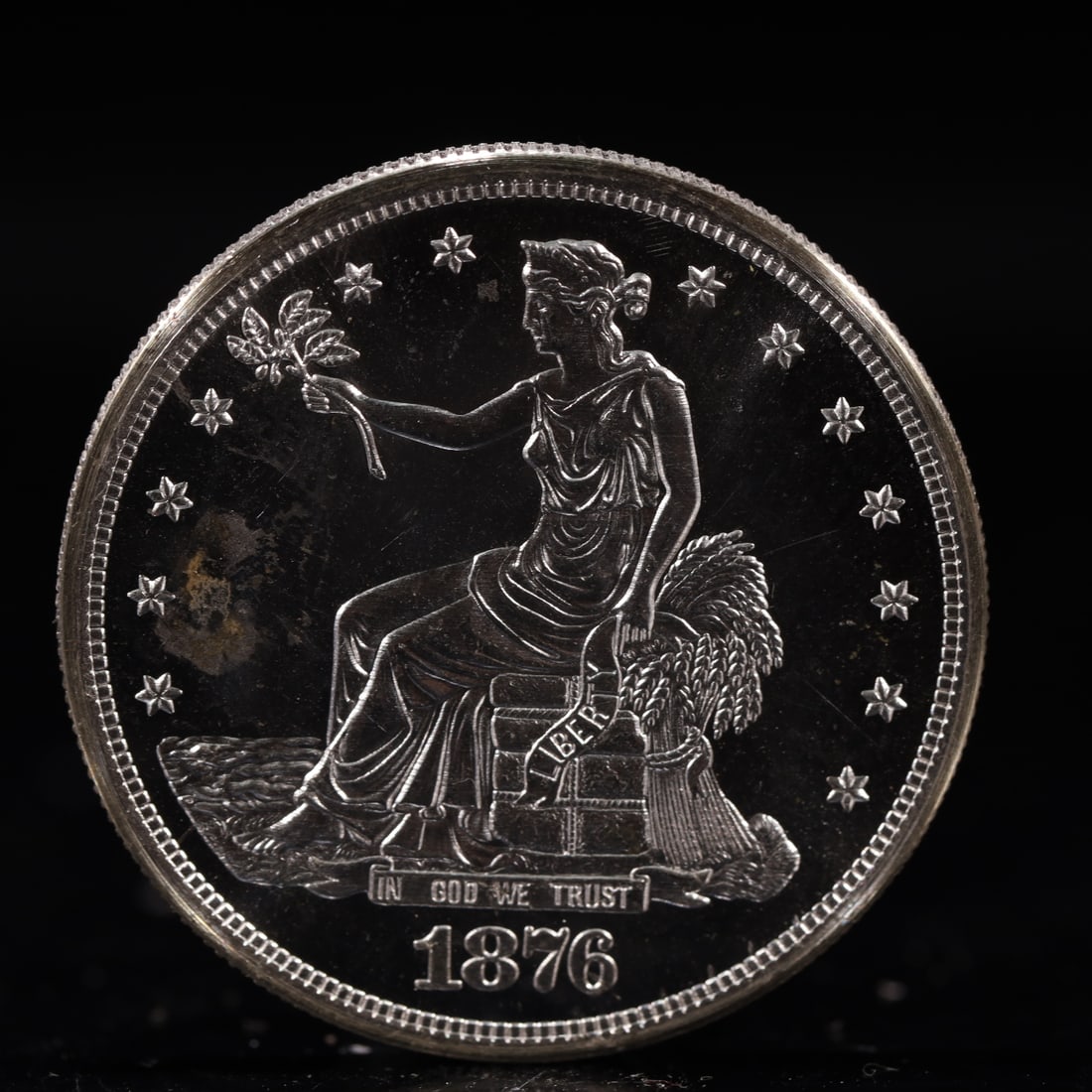 USA Trade Dollar 1876 Coin: American coin. Obverse: Liberty seated on a pedestal facing the sea to the left holding olive branches surrounded by 13 stars. IN GOD WE TRUST / LIBERTY / 1876. Reverse: An eagle holding branches with