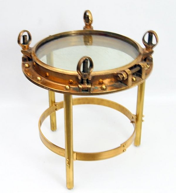 Porthole Side Table: Porthole, ½" thick brass with original glass & screw clamps; rests on custom-made brass stand to serve as a small table; table top height 20.5"; overall h 23.5"; diameter 20.5"; weight 85 lbs. **