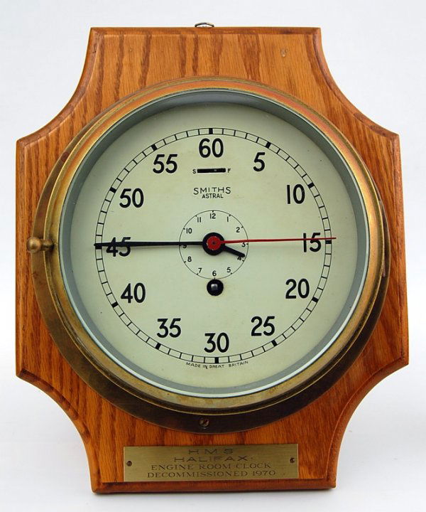 HMS Halifax,Ship's Clock by Smiths: Ship's Clock marked on the face Smith's Astral mounted on an oak backboard with a plaque reading HMS Halifax Engine Room Clock, Decommissioned 1970. Brass case. Size 10' diam. Clock x 3.75"deep Backbo