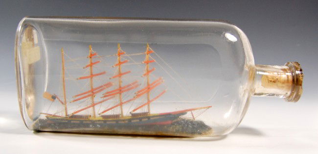 Ship in a Bottle - 4 Mast American Bark: Ship in a Bottle - 4 Mast American Bark - Flying American flag. Blue hull, red waster line and black false gun ports. Interior painted ocean. An early bottle with carved cork stopper. Circa 1910 Condi