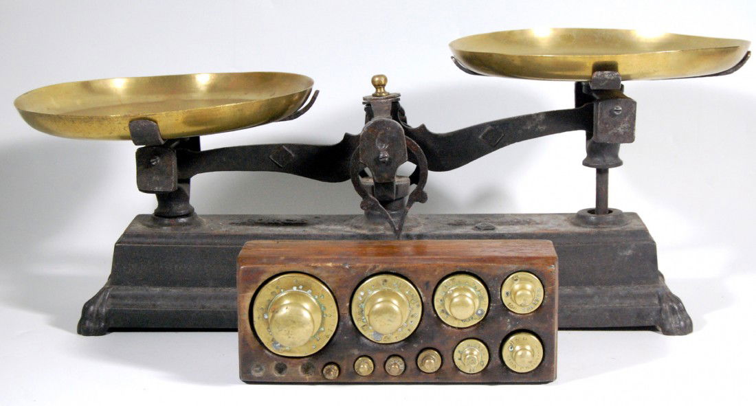 Balance Scale w/ Weights Balance Scale: Balance Scale w/weights - Cast Iron with the words 'Forge' and 'Kilog' . Two brass weighing pans and a set of 10 graduated weights accompany this lot. No maker's mark found. Size: Scale w/pans assembl