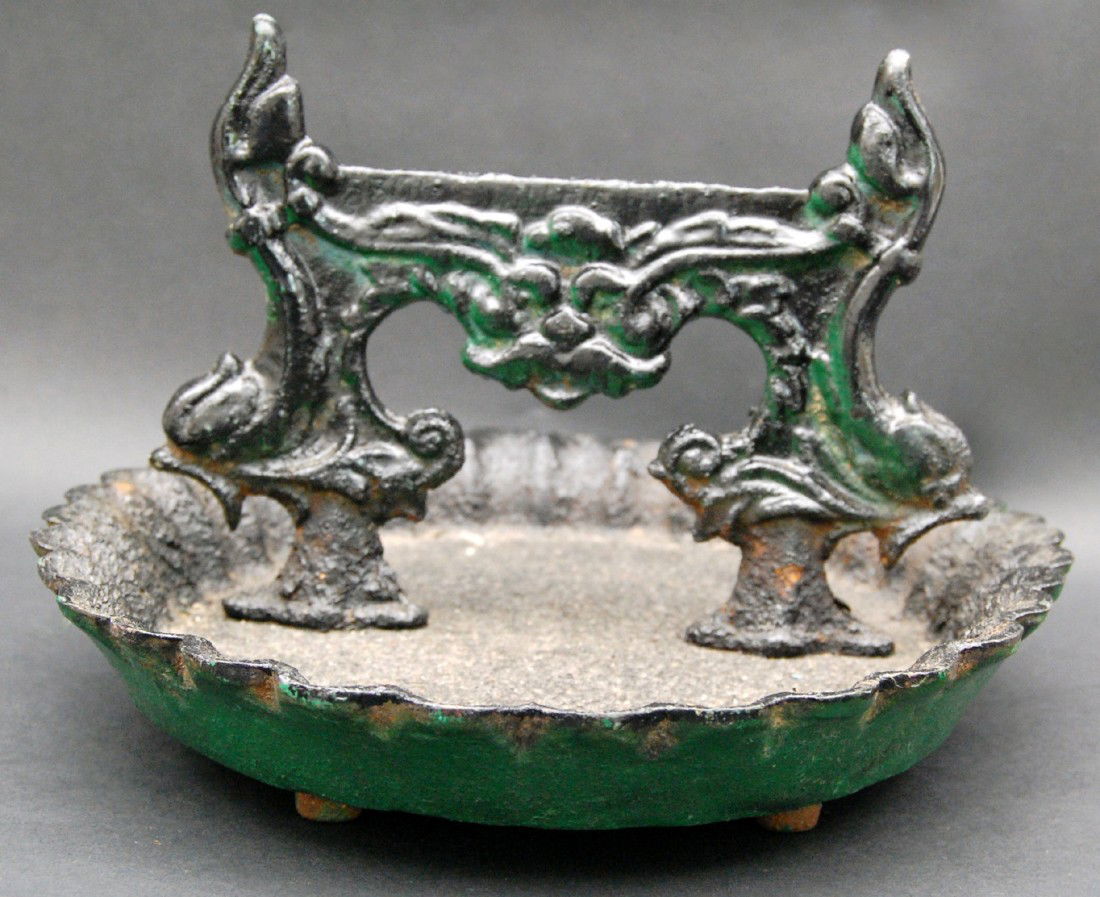 Boot Scraper, Painted Cast Iron on tray.: Boot Scraper, Oval shape, painted black cast Iron on pie crust, flute edged tray that has four feet on the underside. Stylized griffins flank each side of the scraper with a floral motif in the center