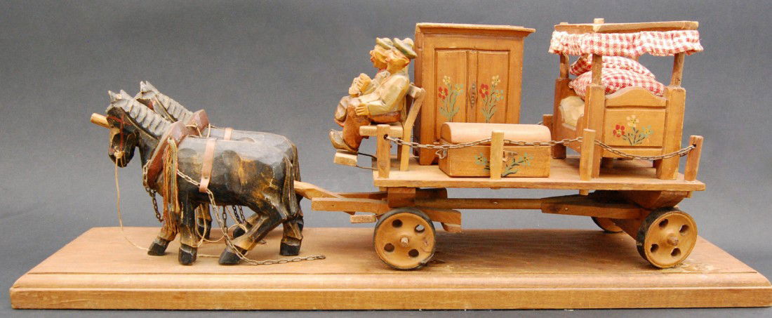 Hurdy Gurdy Wagon, Black Forest Couple seated on a: Couple seated on a wagon with bed, trunk and working music box. Carved wood from the Black Forest Region, early 20th century. Size: 7.5" H x 19 3/4" L x W: 5" Weight: 3lbs 7.2oz Condition: losses to c