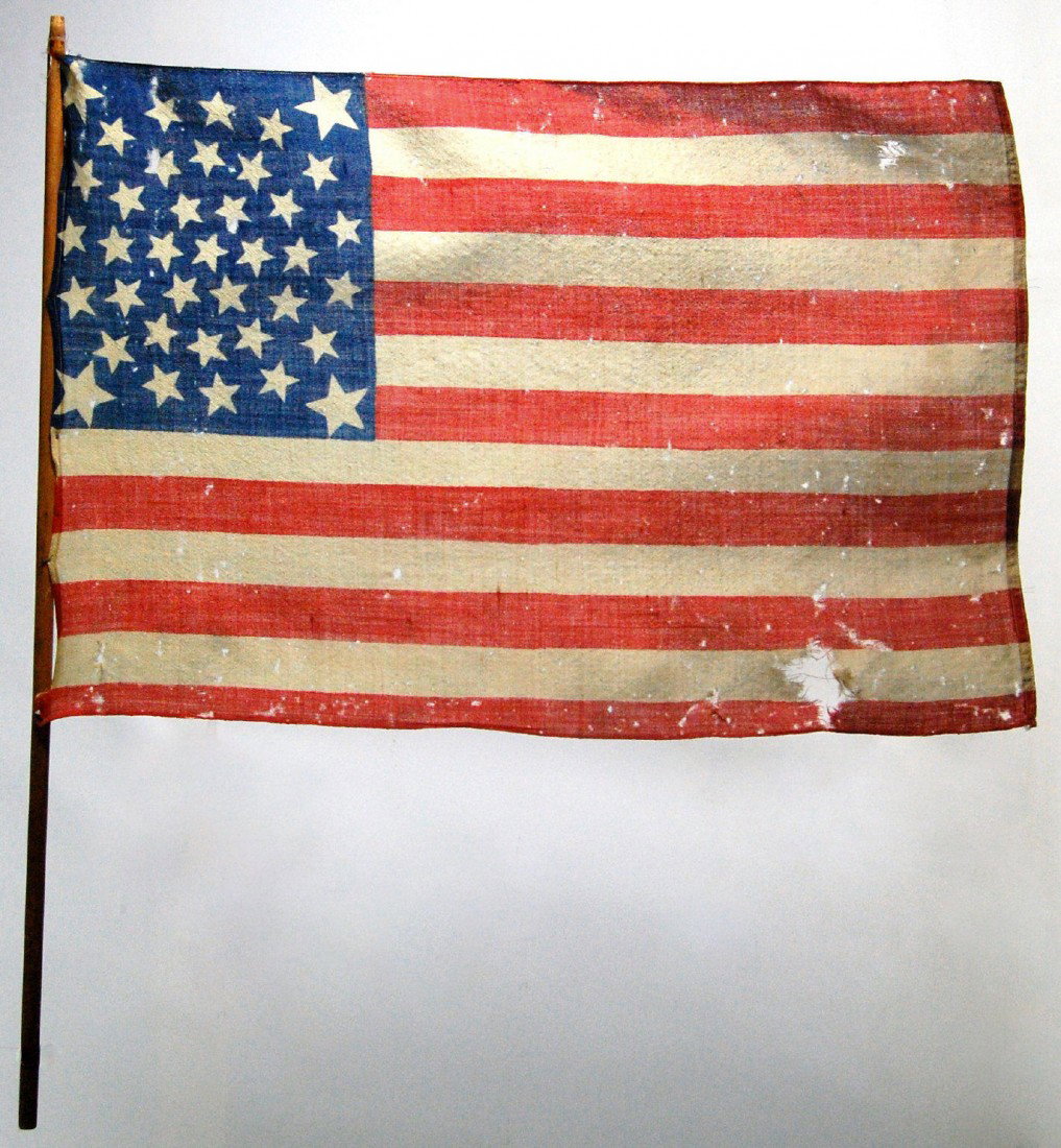 Flag, 38-star Amer., 1877-90 Period, parade flag h: Period, parade flag having a printed, Medallion pattern, 38-stars. Wool and now mounted on a old wood Three rings of stars encircle a single star with a star in each corner. Sewn edges. A letter from 