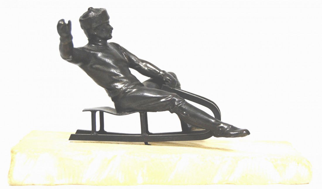 Russian Sledder cast bronze figure on alabaster: Russian Sledder cast in bronze and mounted on a carved alabaster base to represent ice with sled runner marks in its surface. Size: 5.75" x 2.5" x 3.5" Weight: 1lb Condition: Very good