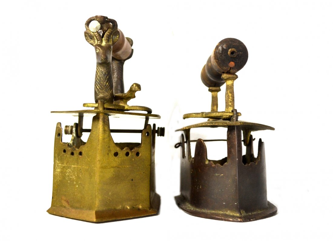 (2) Irons , Brass: Irons (2), Brass- Two brass flatirons. Wood handled, sand cast. Size: 6.5" H. x 4" W. x 5.25" D.; 5.75" H. x 5.5" W. x 4.5" D. Weight: 6lbs.