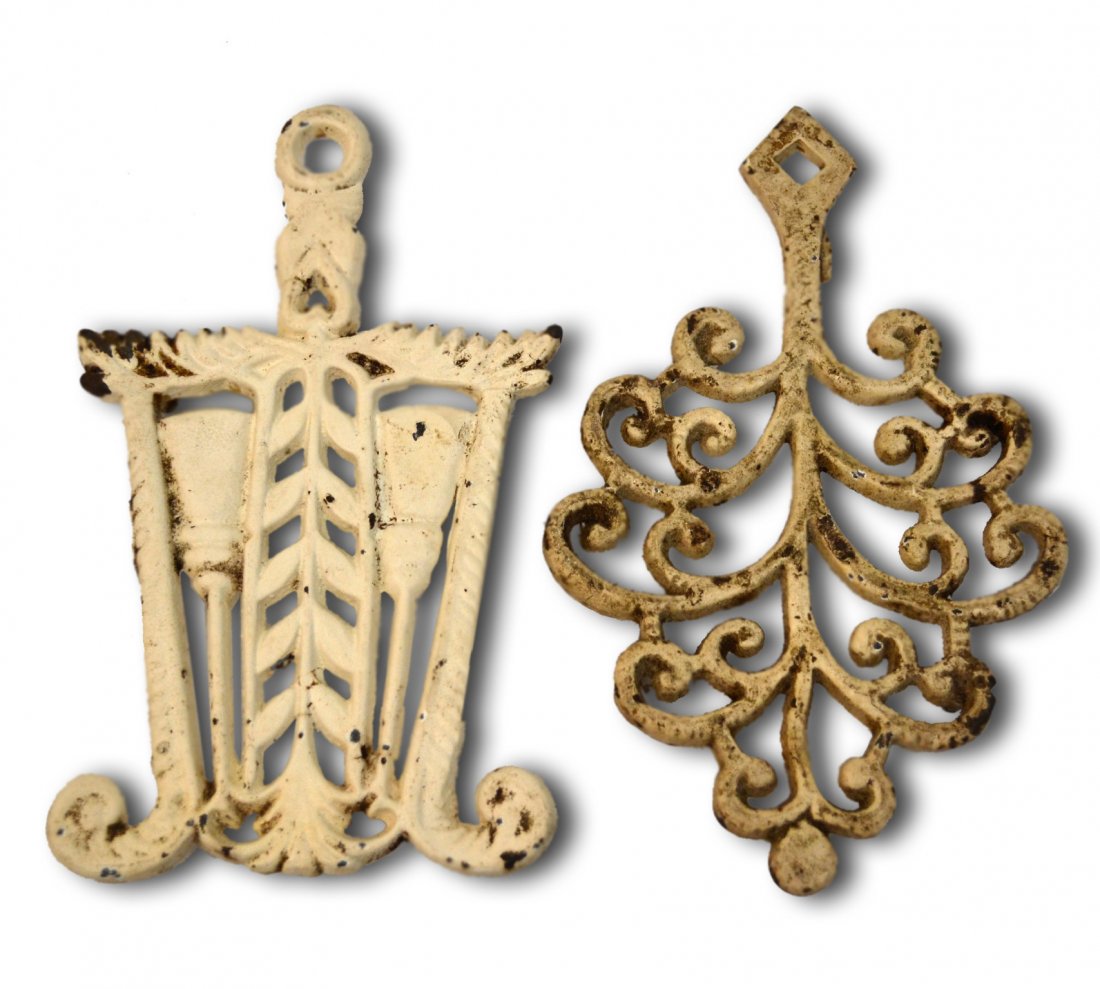 Trivets, 2 cast iron, white paint: Trivets, 2 footed cast iron, painted white. One a floral basket design and one a tree design. Size (1): 8" H. x 5" W. Size (2): 7.75" H. x 5" W. Weight: 1lbs 8oz