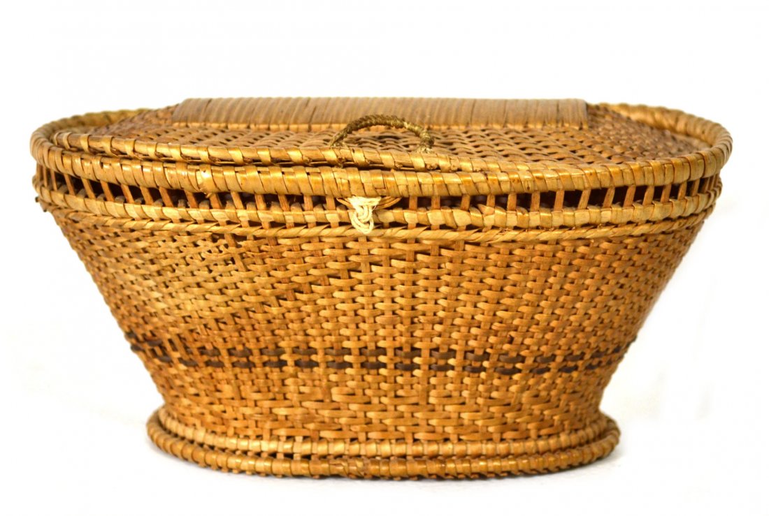 Miniature Oval Shaker Basket With Lid, 20th C: Small Oval Shaker Basket With Lid. Handle on top of lid. Two darker brown weaves wrapping around basket towards bottom. 20th century. Size: 3" H. x 5.75" W. x 3 3/8" D. Weight: 1oz