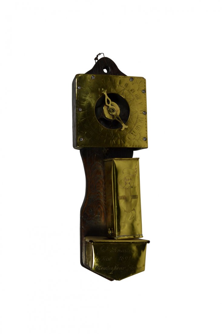 Water Clock, Brass, Circa 1880: Water Clock, Brass, Circa 1880 Water clock. Material: Brass and mahogany. Construction: Sheet brass riveted into wood back. Features: Engraved on the face of the clock are roman numerals and suns risi