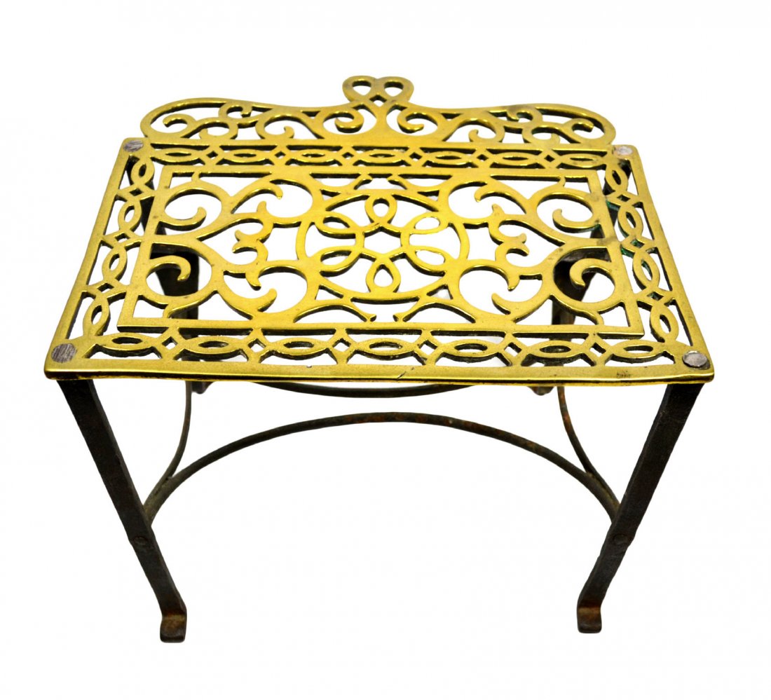Footman stool, Trivet, brass footed, C. 1840: Footman stool, Trivet, brass footed, C. 1840 Brass footed trivet Material: Brass, cast iron Construction: Brass legs riveted to cast iron frame Features: Brass footman stool, trivet with two Chippenda