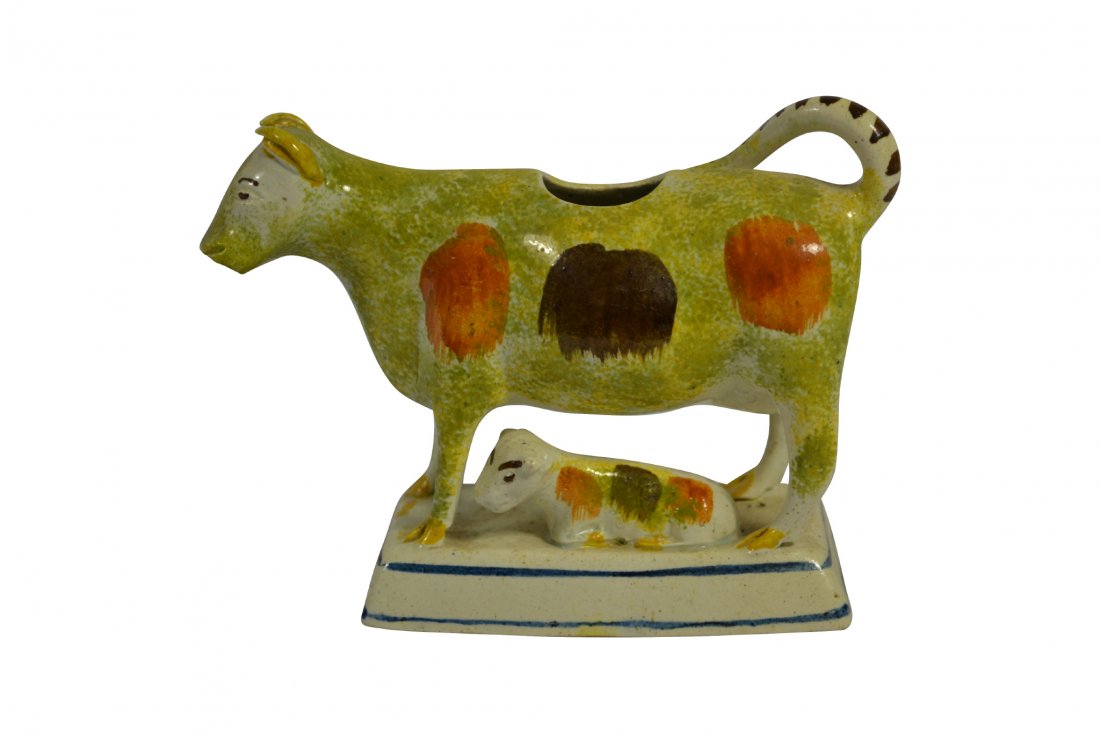 Creamer, Prattware, Cow, 18th Century: Creamer, Prattware, Cow, 18th Century Form: Cream pitcher Components: Hard paste Decoration: Sponge painted decoration. Cow and calf rest on a rectangular base. Upturned tail forms the handle. Colors: