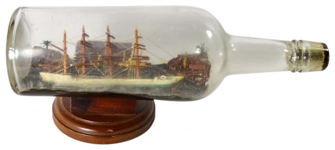Ship in a Bottle, Mildred, c.1920: Ship in a Bottle, Mildred, c.1920 Ship in a bottle Material: Glass, mahogany, balsa, paint, twine Maker & Markings: Sailor made ship in a bottle, hand painted on the starboard side is the ships name "