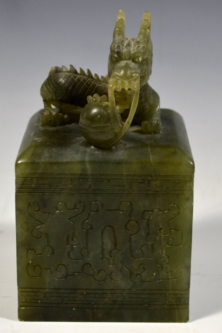 Spinach Jade Chinese Carved Dragon: Dragon Materials: Jade Marks: None Country of Origin: China Description: A carved dragon rests on a carved square base. Wrapping around the base is an incised border and decoration. Size: 5.5" H x 3.2