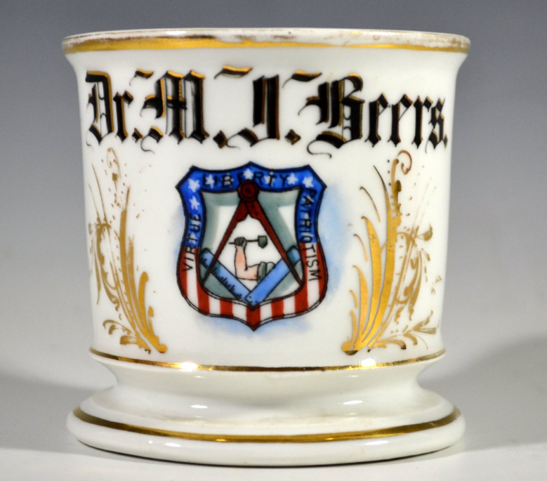 Shaving Mug, America, Patriotic: Shaving Mug Material: Porcelain Marks: Gold diamond on bottom Colors: Gold, black, red and blue Features: Reads "Dr. M. R. Beers" and inside an American shield reads "Viture Liberty Patriotism." Perio