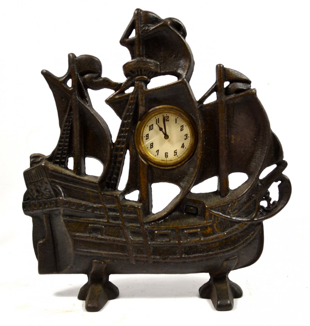 Doorstop & Clock, Ship, Cast Iron, 20th Century: Doorstop / clock Material: Cast Iron Description: A clock within a cast iron ship doorstop with three masts. Construction: Cast Date: 20th Century Size: 10.5" L x 11.5" W x 3" D Weight: 5.1b Condition
